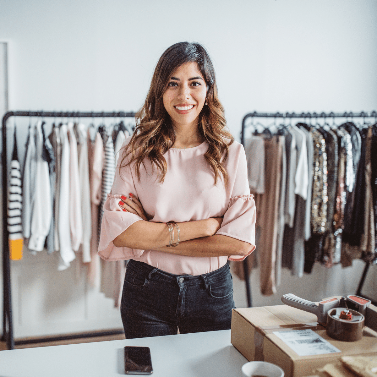 retail-stock-1 Retail store owner standing at a counter surrounded by clothing racks, emphasizing Zoku's omni-channel solution.