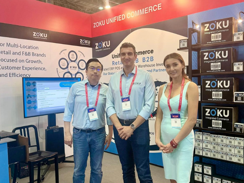 Trade show booth with three attendees.