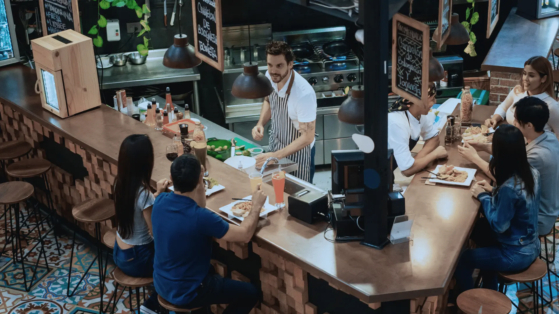 foodandbev Restaurant staff assisting customers at the counter with the Zoku Point of Sale system in a busy F&B setting.